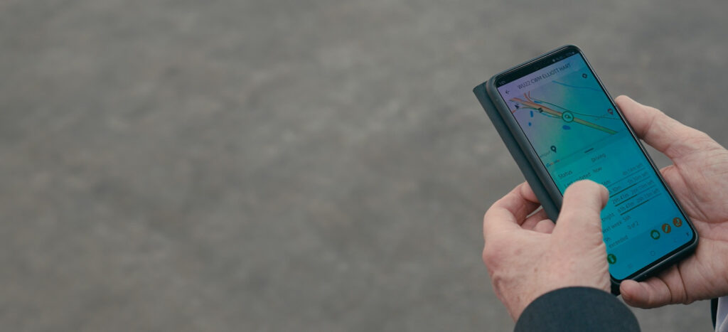 Man holding a mobile phone using the Fleet Witness App